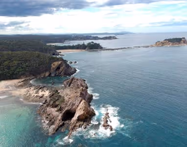 An aerial image of a beach in south coast with a big cliff.